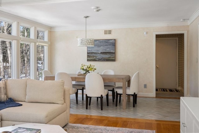 dining area featuring hardwood / wood-style flooring and ornamental molding