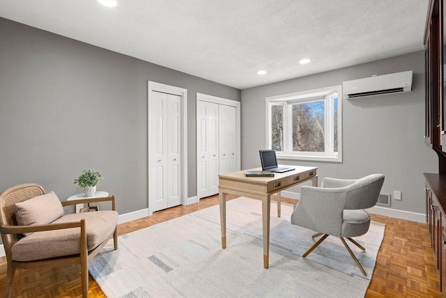 office space featuring light parquet floors, a wall mounted air conditioner, and a textured ceiling