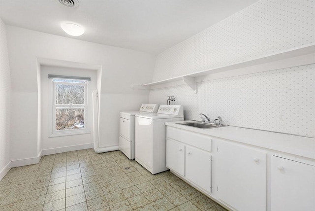 laundry area featuring cabinets, washer and dryer, and sink