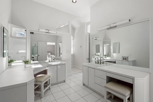 bathroom with tile patterned floors, vanity, and a high ceiling