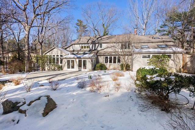 view of snow covered back of property