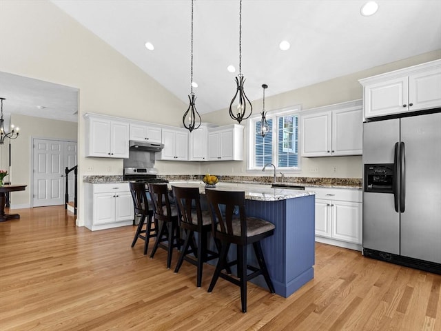 kitchen featuring white cabinets, a notable chandelier, light wood-style flooring, stainless steel appliances, and under cabinet range hood