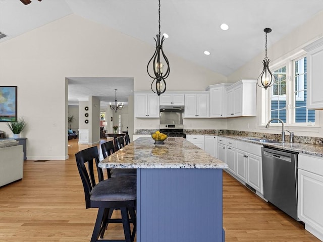 kitchen featuring a breakfast bar, a center island, white cabinetry, a sink, and stainless steel appliances