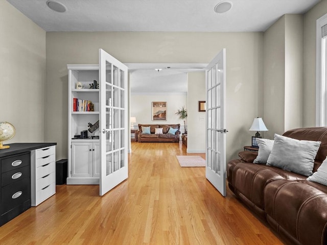 living area featuring french doors and light wood finished floors