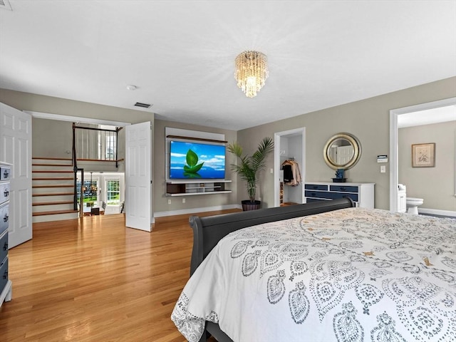 bedroom with baseboards, visible vents, light wood-type flooring, and a notable chandelier