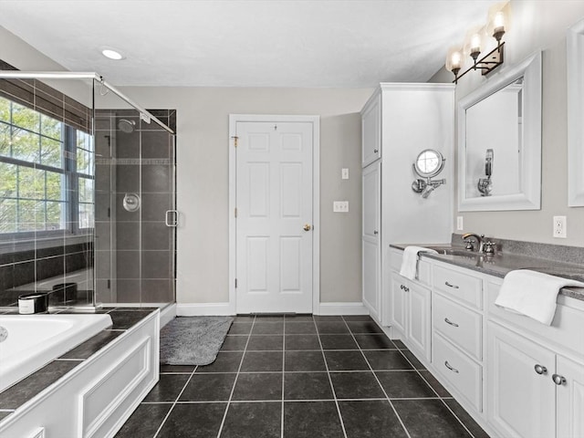 full bathroom featuring vanity, tile patterned floors, baseboards, a garden tub, and a stall shower