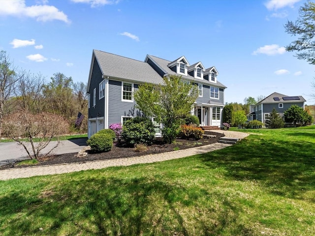 view of front of home featuring an attached garage, driveway, and a front yard