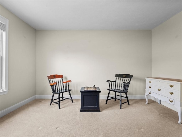 sitting room featuring baseboards, a wealth of natural light, and carpet