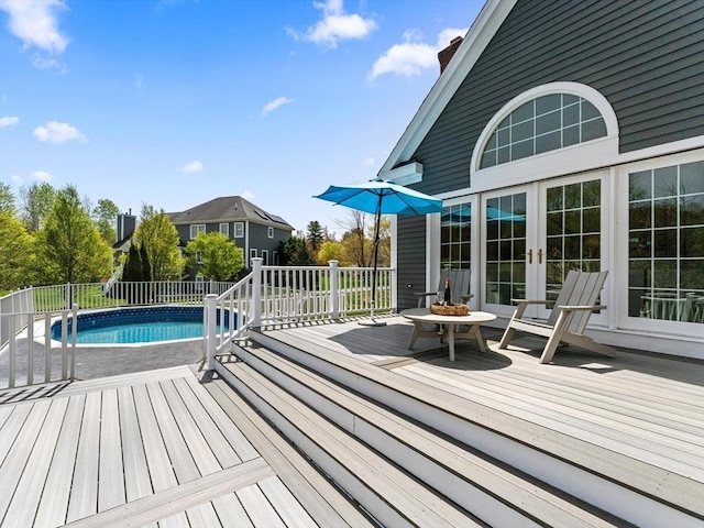 deck featuring fence, a fenced in pool, and french doors