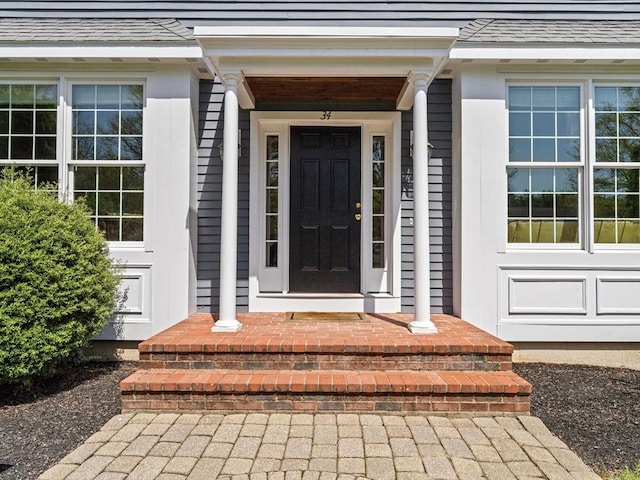 entrance to property with roof with shingles
