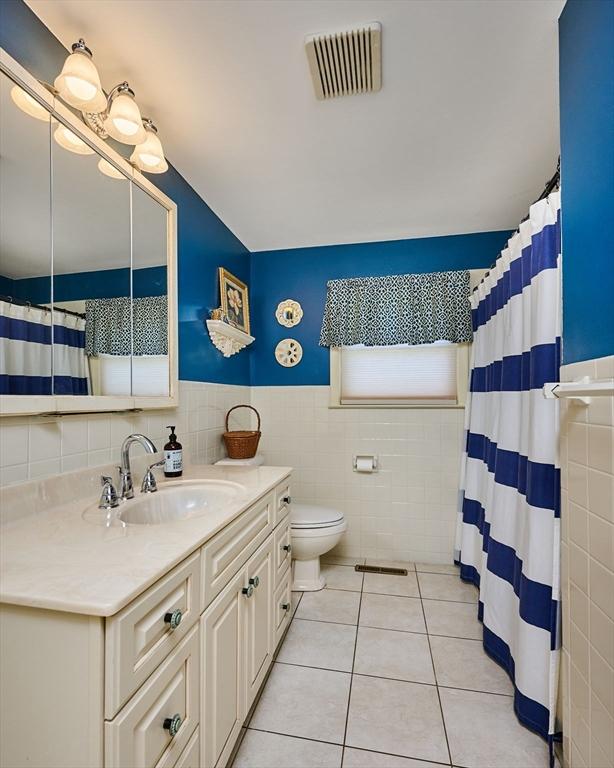 985 Tinkham Rd, Wilbraham, MA 01095 - bathroom with tile walls, vanity, tile patterned floors, a shower with curtain, and a wainscoted wall