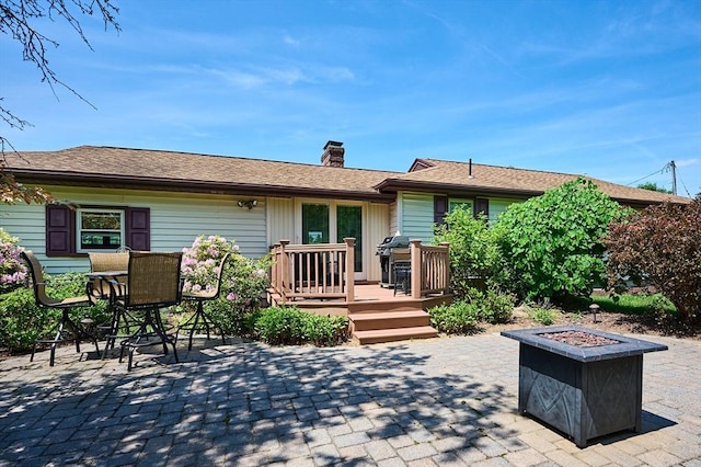 985 Tinkham Rd, Wilbraham, MA 01095 - back of property with a deck, a fire pit, a chimney, and a patio area