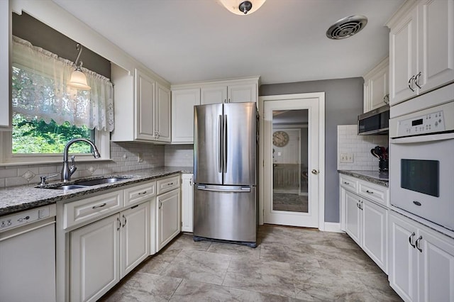 985 Tinkham Rd, Wilbraham, MA 01095 - kitchen featuring appliances with stainless steel finishes, decorative backsplash, light stone counters, white cabinets, and decorative light fixtures