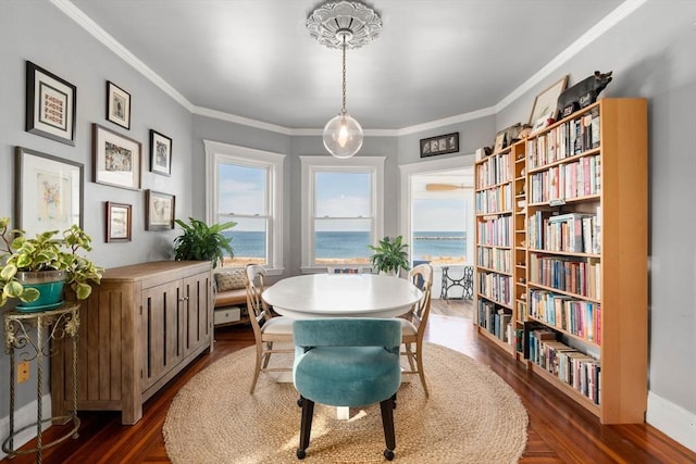 sitting room with ornamental molding, a water view, and dark wood-type flooring