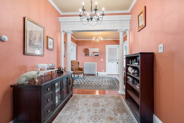 foyer entrance featuring radiator heating unit, crown molding, and wood-type flooring