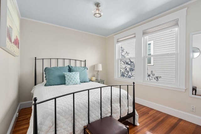 bedroom with crown molding and dark hardwood / wood-style flooring