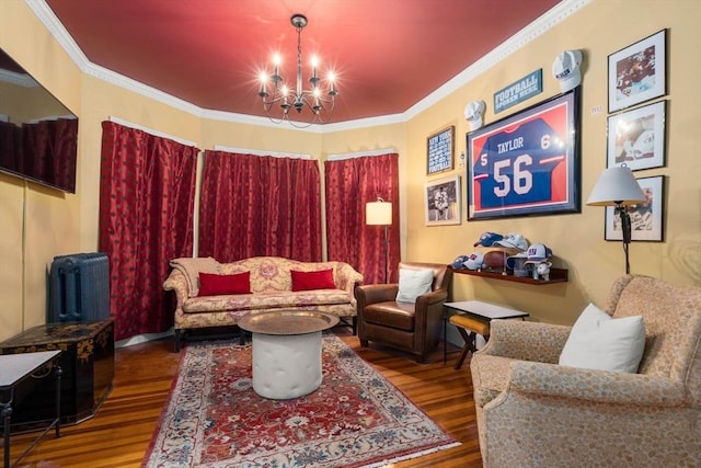 living room with crown molding, hardwood / wood-style floors, and a notable chandelier