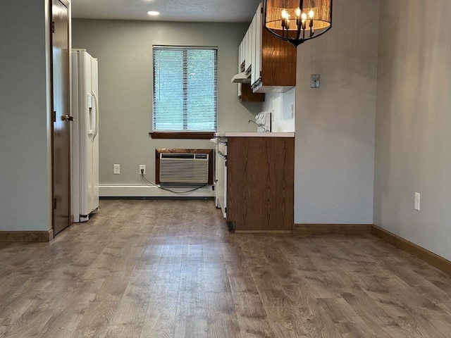 82 S Maple St Unit 44, Westfield, MA 01085 - kitchen with under cabinet range hood, a chandelier, wood finished floors, white refrigerator with ice dispenser, and light countertops