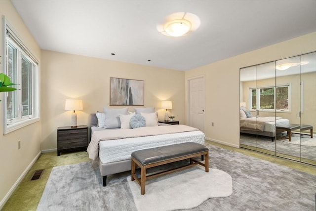 bedroom featuring light colored carpet and a closet