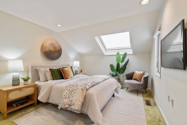 carpeted bedroom featuring vaulted ceiling with skylight