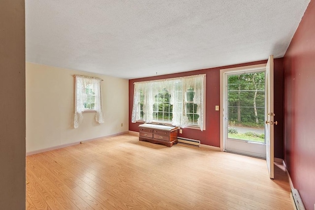 336 Otter River Rd, Templeton, MA 01468 - unfurnished room featuring a baseboard heating unit, a textured ceiling, light wood-style flooring, healthy amount of natural light, and baseboard heating