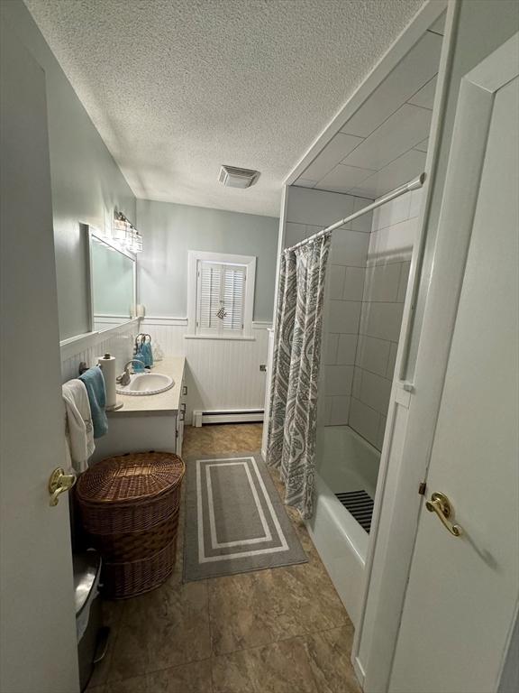 64 Edgewater Dr, Wareham, MA 02571 - full bathroom featuring vanity, baseboard heating, a textured ceiling, a wainscoted wall, and visible vents