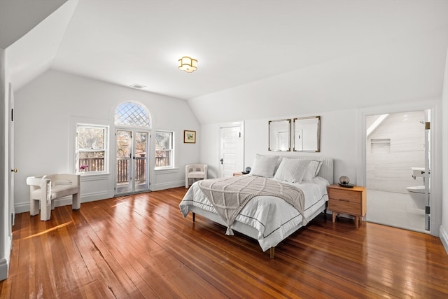 bedroom featuring hardwood / wood-style floors, connected bathroom, and vaulted ceiling