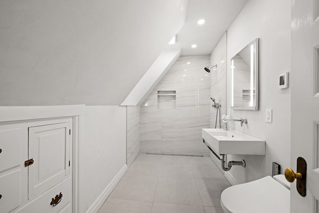 bathroom featuring toilet, sink, tile patterned flooring, and tiled shower