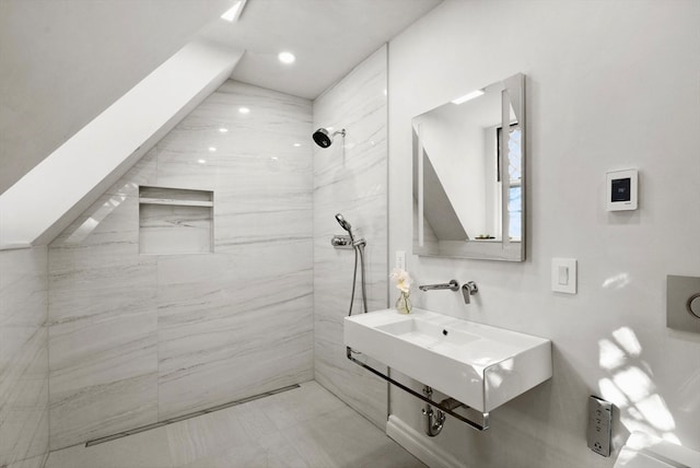 bathroom featuring tiled shower and sink