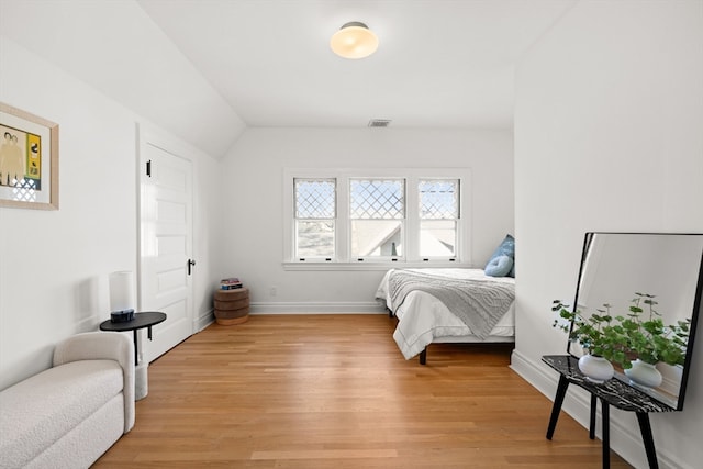 bedroom with vaulted ceiling and light wood-type flooring