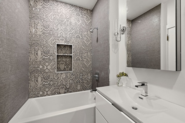 bathroom with tiled shower / bath combo and vanity