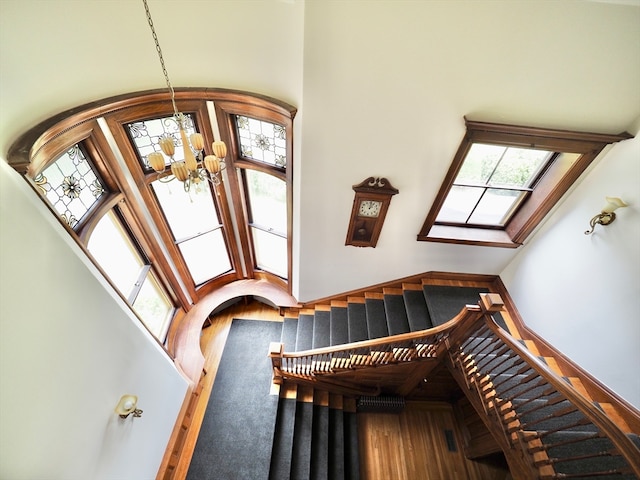 interior space featuring hardwood / wood-style floors, a healthy amount of sunlight, and a towering ceiling