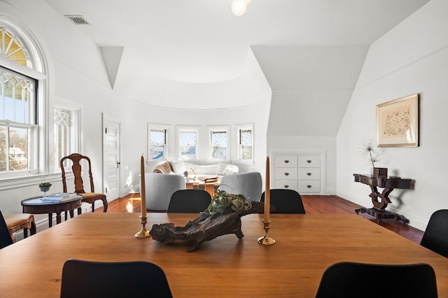 dining space featuring light hardwood / wood-style floors and lofted ceiling