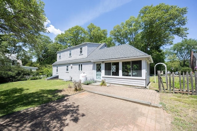 4 Cypress Rd, Natick, MA 01760 - view of front of house featuring a front yard, a patio, roof with shingles, and a sunroom