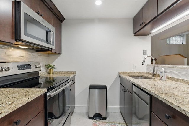 35 Nonantum St Unit E, Boston, MA 02135 - kitchen featuring appliances with stainless steel finishes, a sink, decorative backsplash, dark brown cabinets, and recessed lighting