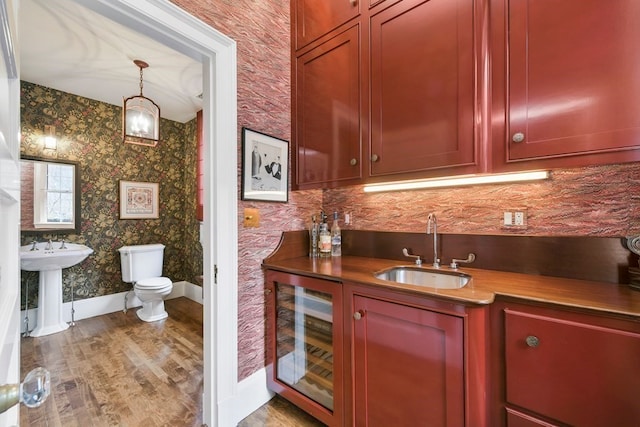 bar featuring dark hardwood / wood-style floors, sink, beverage cooler, and pendant lighting