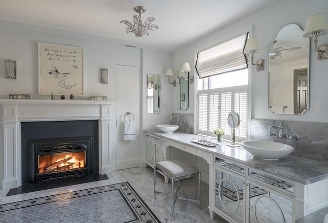 bathroom with a notable chandelier, double sink vanity, and tasteful backsplash