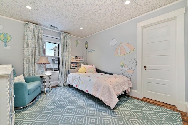 bedroom with crown molding, dark wood-type flooring, and a textured ceiling