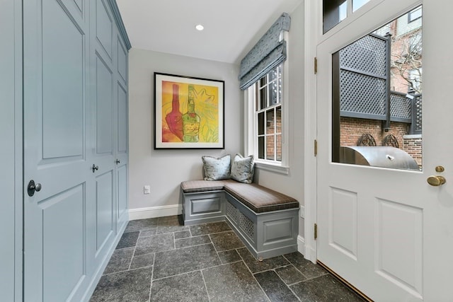 mudroom with dark tile flooring