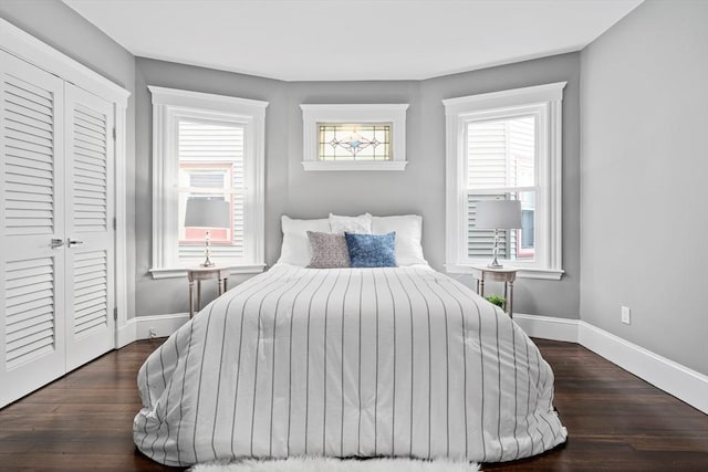 bedroom featuring a closet, wood finished floors, and baseboards