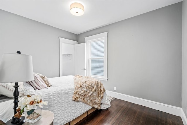 bedroom with baseboards and wood finished floors