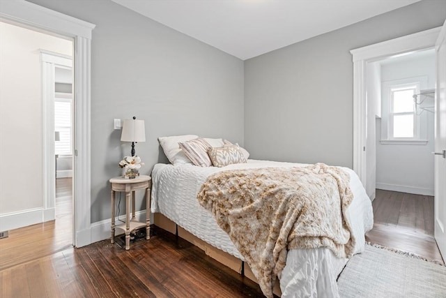 bedroom with dark wood-style flooring and baseboards