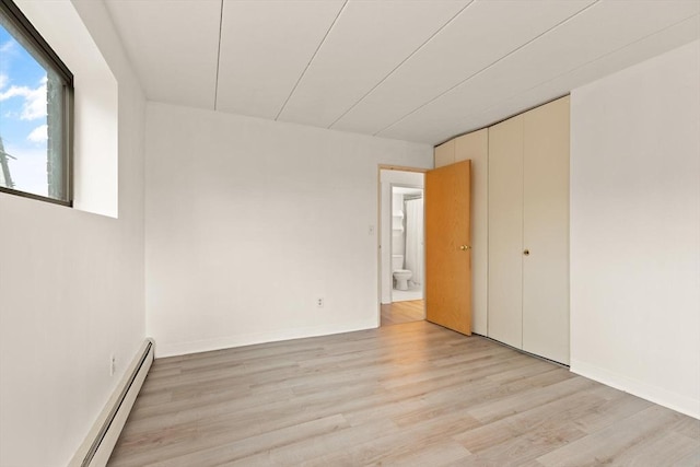 995 Massachusetts Ave Unit 301, Arlington, MA 02476 - unfurnished room featuring a baseboard heating unit and light wood-style flooring