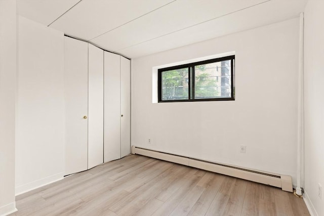 995 Massachusetts Ave Unit 301, Arlington, MA 02476 - unfurnished bedroom featuring baseboard heating and light wood-style flooring