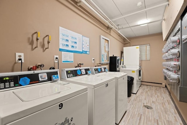 995 Massachusetts Ave Unit 301, Arlington, MA 02476 - shared laundry room featuring washer and clothes dryer, baseboard heating, and light wood finished floors