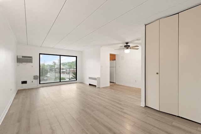 995 Massachusetts Ave Unit 301, Arlington, MA 02476 - unfurnished living room with radiator, a wall mounted AC, light wood finished floors, and a ceiling fan
