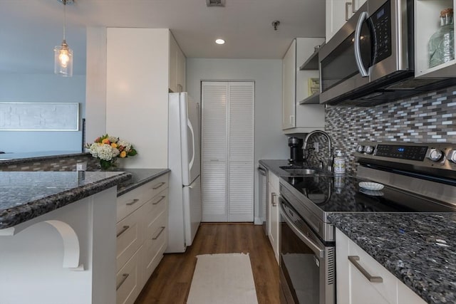 130 Tudor St Unit D, Boston, MA 02127 - kitchen with appliances with stainless steel finishes, tasteful backsplash, dark wood-type flooring, white cabinetry, and recessed lighting