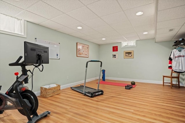 exercise room featuring hardwood / wood-style floors and a paneled ceiling