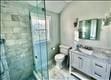 bathroom featuring toilet, vanity, and walk in shower