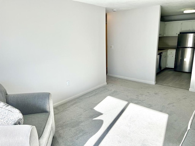 interior space featuring light colored carpet and baseboards